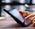 Woman pointing on digital tablet screen, chatting in social networks, meeting website, searching internet, sending sms, using text messenger or online banking. Close up of female hands holding device